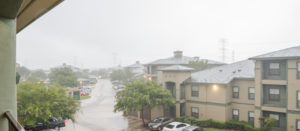 Harvey storm/hurricane heavy rain over a typical apartment complex building in suburban area at Humble, Texas, US. Parked cars on uncovered parking lot along apartment blocks. Severe weather. Panorama